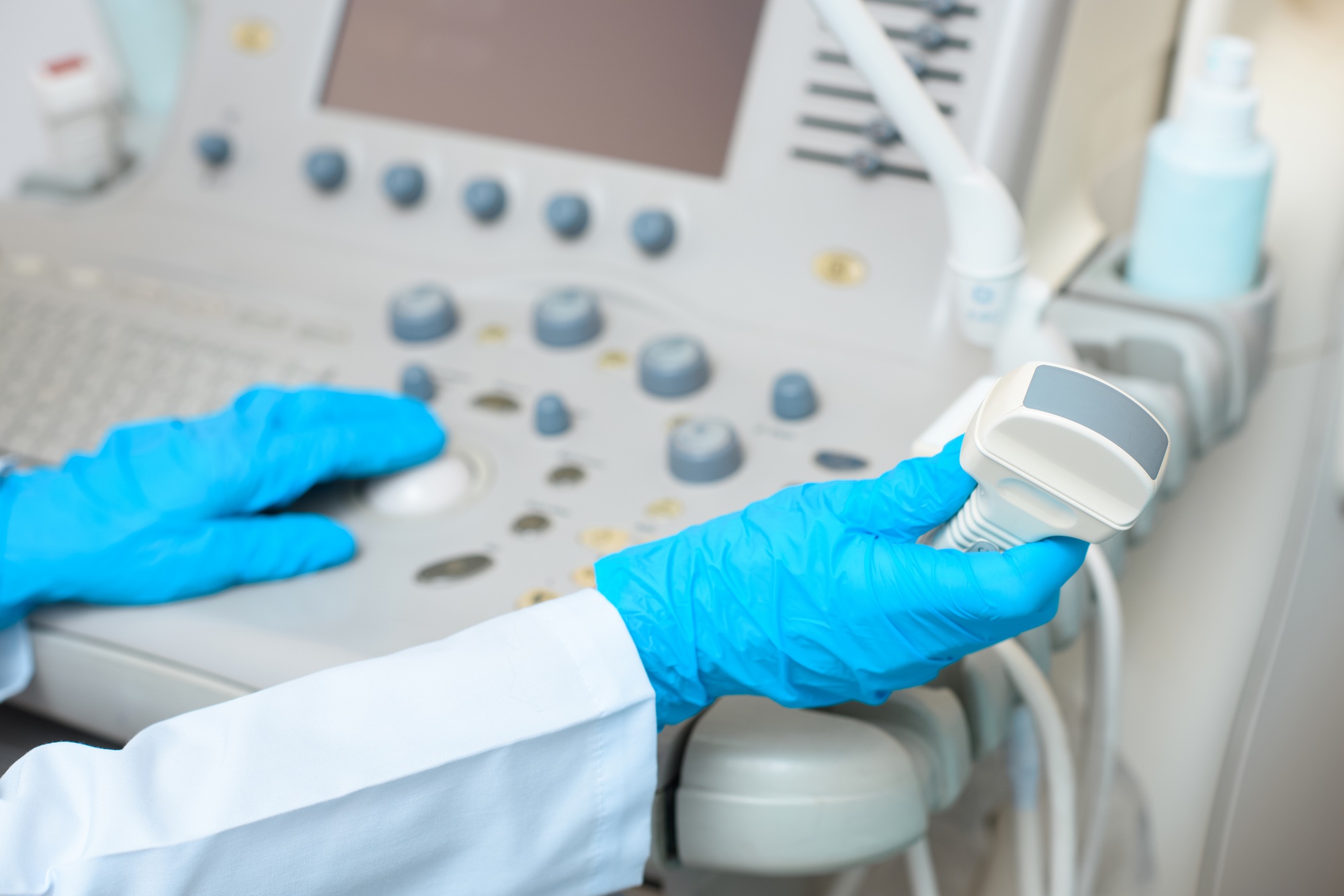 cropped shot of obstetrician gynecologist in gloves working with ultrasonic scanner